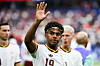 Lamine Yamal hebt im WM-Halbfinale gegen Frankreich die Hand, im Hintergrund weitere Spieler im Stadion.