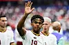 Lamine Yamal hebt im WM-Halbfinale gegen Frankreich die Hand, im Hintergrund weitere Spieler im Stadion.