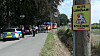 Polizei und Feuerwehr sperren in Halstenbek ein Gelände ab, ein Warnschild steht am Wegesrand, Drohnen suchen nach einer Giftschlange.