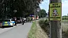 Polizei und Feuerwehr sperren in Halstenbek ein Gelände ab, ein Warnschild steht am Wegesrand, Drohnen suchen nach einer Giftschlange.