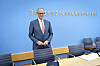 Friedrich Merz steht vor blauem Hintergrund bei der Bundespressekonferenz in Berlin.