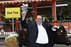 Ottfried Fischer winkt vor einem Bad-Tölz-Schild neben einem Rind beim Empfang in München.