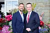 Jens Spahn und Daniel Funke stehen vor Blumen beim Sommerfest von 'Ein Herz für Kinder'.