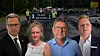 Demonstrierende mit Banner vor dem Rathaus; vier Personen im Vordergrund.