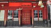 Rotes Ladenlokal mit Schaufenstern und zentralem Eingang, darüber der Schriftzug „barbarabar“.