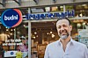 Mann vor dem Eingang eines Budni-Drogeriemarkts mit blau-rotem Logo.