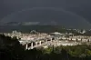 Regenbogen über der Brücke San Giorgio in Genua bei dunklem Himmel.