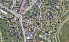 Luftaufnahme eines Wohngebiets mit Straßen, Gärten, Bäumen und einem Friedhof.