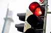 Rote Ampel vor unscharfem Hintergrund, im Hintergrund eine weitere Verkehrsampel.