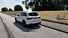 Weißer SUV an einer Landstraße, daneben liegt ein umgestürztes Fahrrad auf einer Böschung.