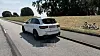 Weißer SUV an einer Landstraße, daneben liegt ein umgestürztes Fahrrad auf einer Böschung.