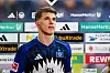 Luka Vuskovic vom Hamburger SV vor der Sponsorenwand im Stadion.