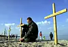 Martin Götz stellt am Strand von Boltenhagen Holzkreuze zum Gedenken an DDR-Fluchtopfer auf.