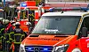 Polizei und Feuerwehr sichern eine Unfallstelle mit Einsatzfahrzeugen auf einer Stadtstraße ab.