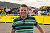 Jan Ullrich lächelt im Zielbereich der Tour de France in Le Markstein vor gelben Absperrungen.
