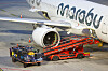 Koffer und Gepäckwagen an einem Marabu-Flugzeug am Flughafen Hamburg zur Verladung bereit.
