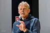 Jürgen Klinsmann spricht mit Mikrofon vor dunklem Hintergrund im German House of Soccer in New York.