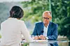 Friedrich Merz spricht beim ZDF-Sommerinterview in Meschede mit Diana Zimmermann am Tisch.