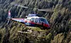 Polizeihubschrauber Libelle Kärnten fliegt über bewaldetem Hang bei Heiligenblut.