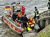 Rettungskräfte bergen eine Person mit einem Boot an einem steinigen Ufer