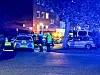 Polizeiwagen und Einsatzkräfte sichern nachts den Bereich vor einem Wohnhaus ab.