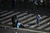 Polizist geht gegen Fan am Obelisk in Buenos Aires vor, Müll liegt auf der Straße.