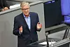 Dietmar Bartsch spricht am Rednerpult im Bundestag vor grauen Sitzreihen.