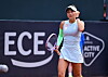 Julia Stusek beim Tennisspiel in Hamburg vor Werbebande.