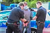 Polizisten führen einen Mann vor einem Streifenwagen am Lidl-Markt in Mümmelmannsberg ab.