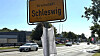 Ortsschild Schleswig an einer Straße mit Autos und Gehweg