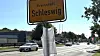 Ortsschild Schleswig an einer Straße mit Autos und Gehweg