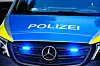 Polizeiauto mit eingeschaltetem Blaulicht und „Polizei“-Aufschrift, Frontansicht
