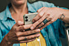 Person hält ein Smartphone in den Händen; Handyversicherung zahlt oft nur den Zeitwert.