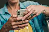 Person hält ein Smartphone in den Händen; Handyversicherung zahlt oft nur den Zeitwert.