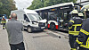 Linienbus und Transporter nach Unfall auf Straße, Einsatzkräfte sichern die Stelle.