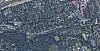 Dicht bebautes Wohngebiet mit Straßenraster und Waldfläche am unteren Rand aus der Luft.