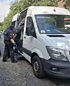 BPOL-Beamte kontrollieren einen weißen Transporter an der geöffneten Seitentür.