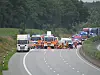 Einsatzfahrzeuge und ein Lkw blockieren die A7 nach einem Unfall.