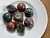 Mehrere Pralinen liegen auf einem weißen Teller auf einem Holztisch.