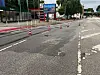 Eine Straße wird von Leitkegeln abgesperrt. Wasser ist auf der Fahrbahn.