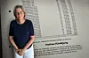 Frau steht vor einer Wand mit Namen und einem Text zur „frisöse Kündigung“ in einem Innenraum.