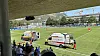 Zwei Rettungswagen auf dem Fußballfeld, Einsatzkräfte auf dem Rasen, Zuschauer auf der Tribüne.