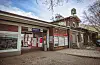 S-Bahnhof Sülldorf mit historischem Schildsignal am Backsteingebäude und Bahnsteigzugang.
