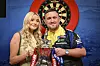 Luke Littler und Faith Millar GodfreyxPitt halten in Blackpool die Betfred-World-Matchplay-Trophäe.