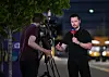 Florian Plettenberg spricht mit Sky-Mikrofon vor dem MetLife Stadium in New Jersey, neben ihm ein Kameramann.