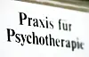 Schild mit der Aufschrift „Praxis für Psychotherapie“ an einer Fassade.