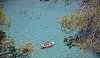 Menschen schwimmen und paddeln im türkisblauen Meer vor Portals Vells auf Mallorca.