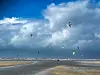 Wohnmobile an den Dünen, Kitesurfer auf dem Wasser unter wolkigem Himmel am Lakolk Strand auf Rømø.
