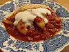 Reis mit Gurken-Tomatensauce und saurer Sahne auf blau-weißem Keramikteller