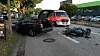 Motorrad liegt nach Kollision mit einem Opel auf der Straße in Hamburg-Lokstedt, Polizei und Rettungswagen im Hintergrund.